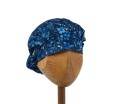 Bawełniany kolorowy czepek  medyczny na długie włosy, damski KOALA drobne niebieskawe listki na granatowym tle.Widok z przodu- związany.