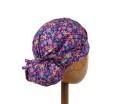 Bawełniany kolorowy czepek  medyczny na długie włosy, damski KOALA w  drobne  żółte, różowe, fioletowe kwiatki na granatowym tle. Widok z tyłu - związany.